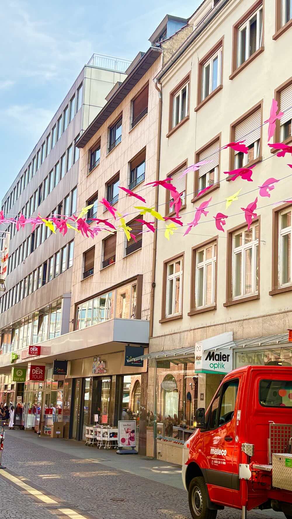 Für dieses Projekt in Karlsruhe haben wir eine farbenfrohe Sommerdekoration mit schwebenden Vögeln entwickelt